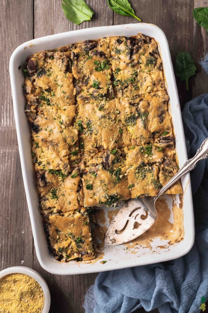 Christmas Recipe - overhead photo of white lasagna on wood background and piece missing