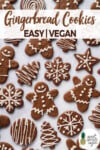 An overhead shot of iced vegan gingerbread cookies on a white marble board for pinterest