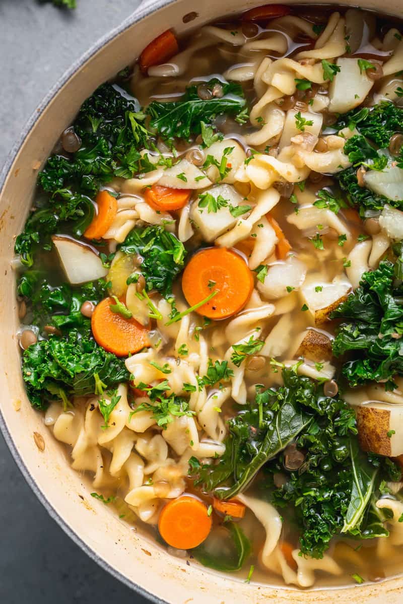 a close up shot of vegetable noodle soup in a pot