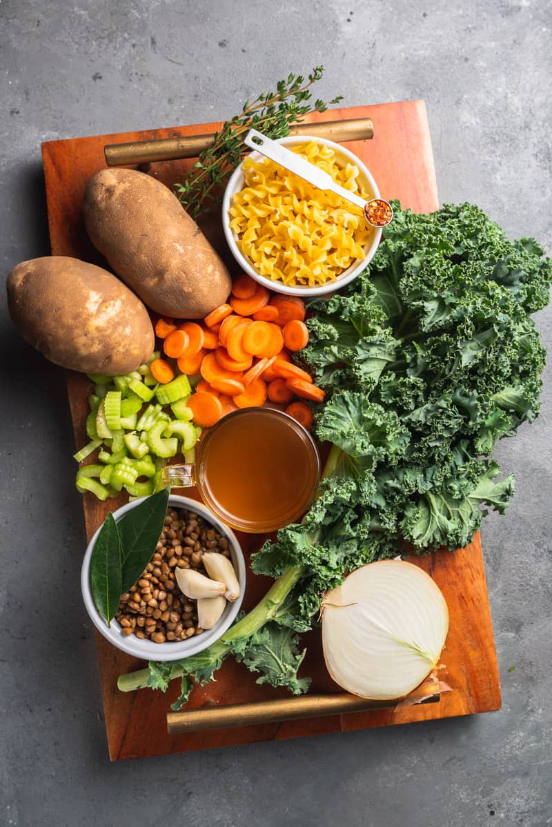 ingredients for vegetable noodle soup on a wooden board