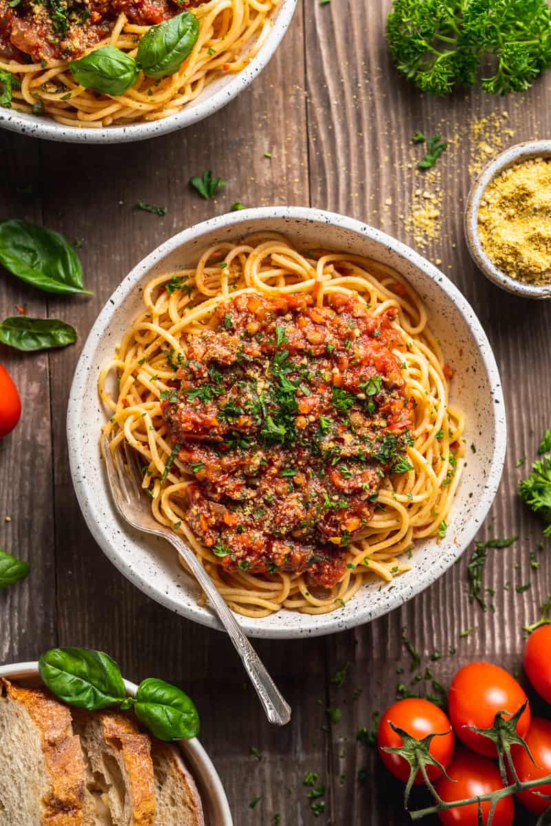 vegan lentil mushroom bolognese​ Sauce on spaghetti in white bowl