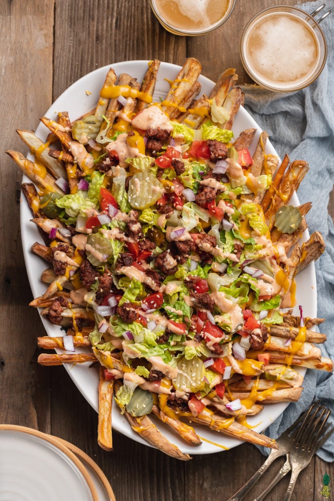 close up of Vegan Big Mac Fries (aka McDonald's Animal Style Fries) with a blue towel and beer