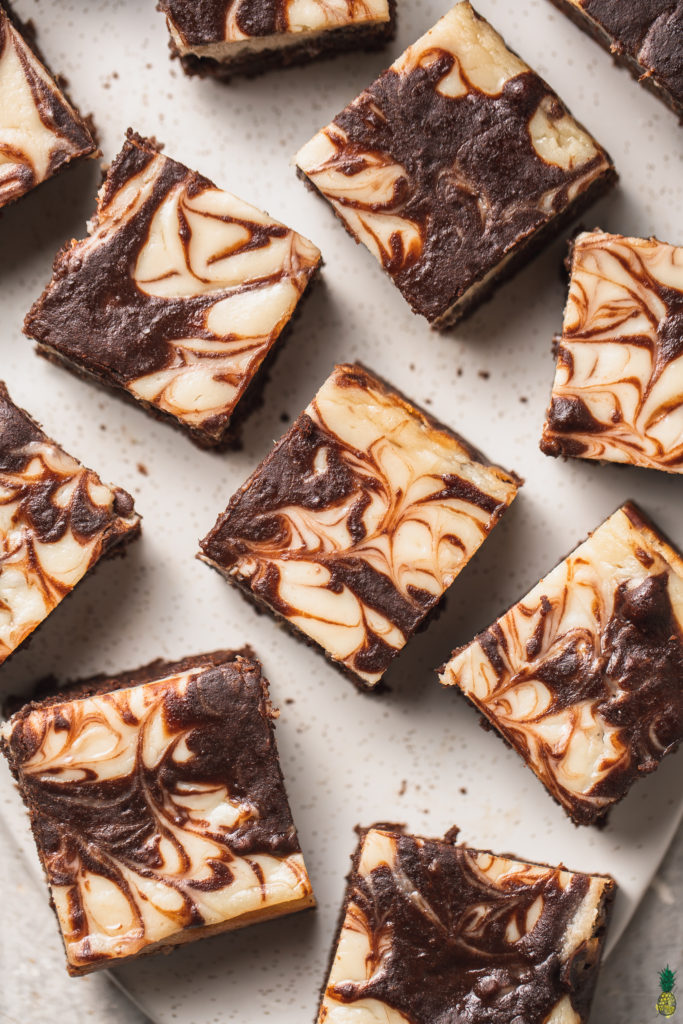 A close up shot of a swirled vegan cheesecake brownie by sweet simple vegan