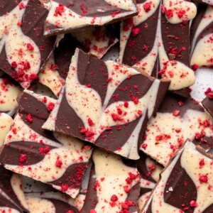 a photo of a pile of swirled chocolate bark with raspberries by sweet simple vegan