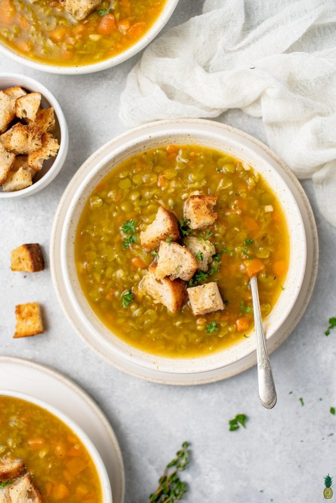overhead image of split pea soup with croutons on top and on the side