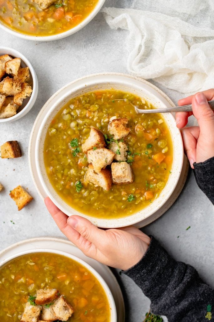 overhead image of split pea soup with hands holding the bowl