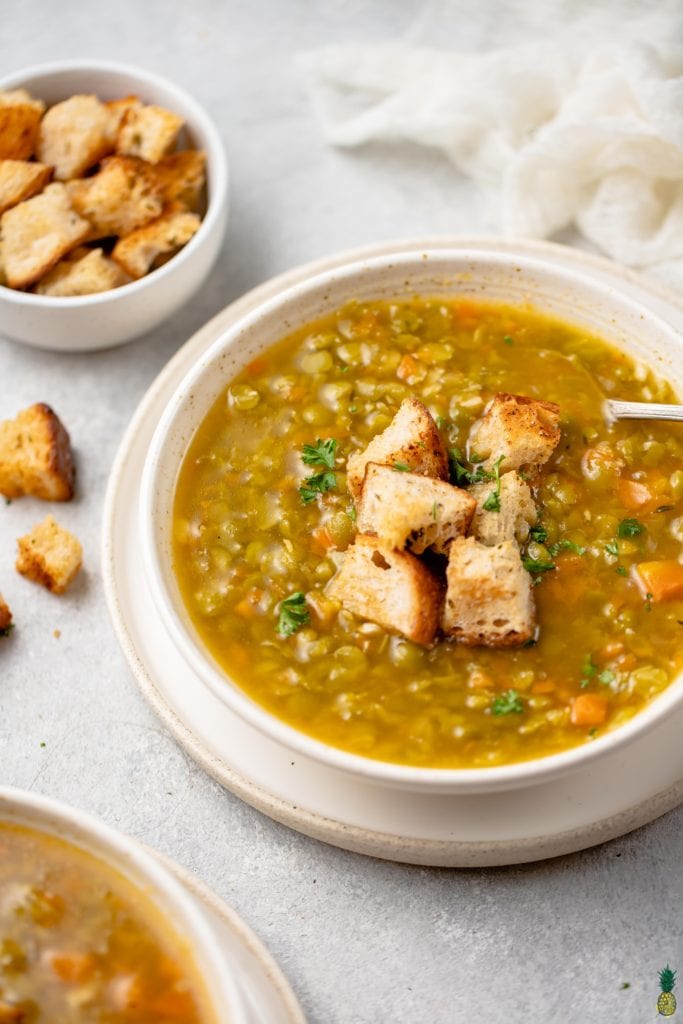 3/4 image of bowl of soup topped with croutons
