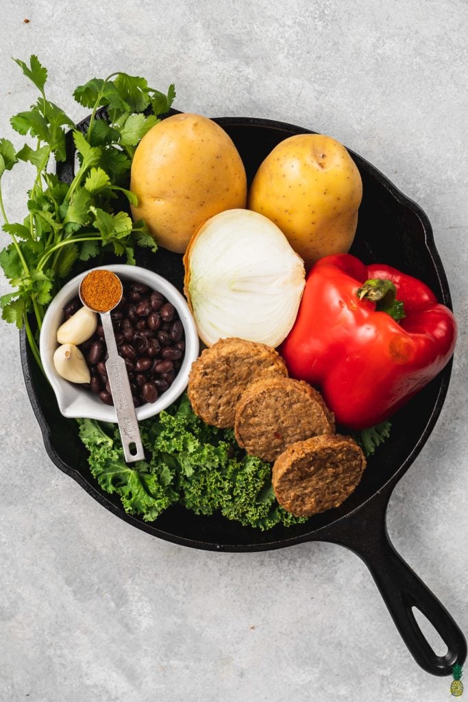 Ingredients for breakfast potato hash in a cast iron skillet