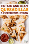 overhead image of sliced quesadillas on baking sheet with salsa and guacamole
