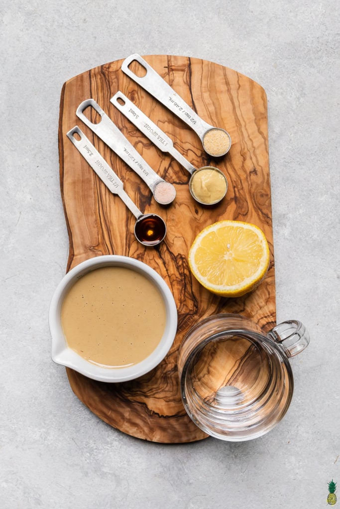 Ingredients to make 5-minute tahini dressing on a wooden board by sweet simple vegan