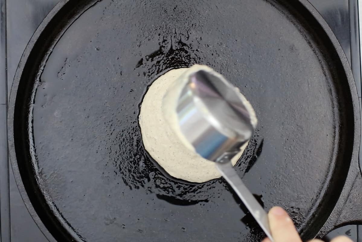 pouring pancake batter onto cast iron griddle