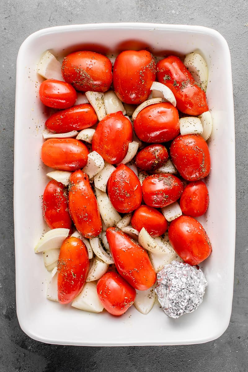 raw tomatoes and onions in a casserole dish