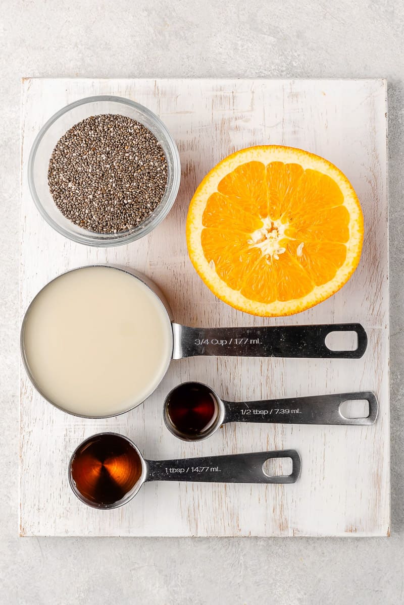 Ingredients to make orange creamsicle chia pudding on a white board by Sweet Simple Vegan Blog