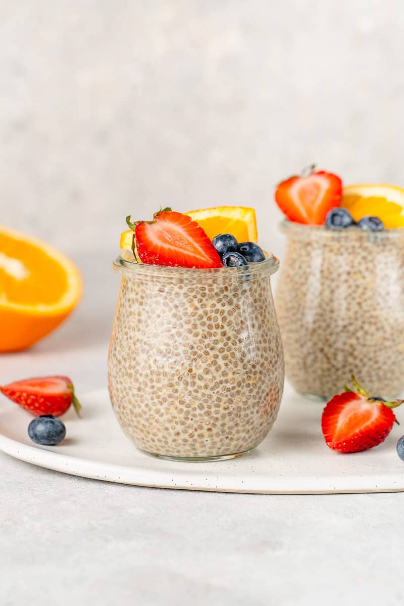 Close up shot of orange creamsicle chia pudding with fruit on top by sweetsimplevegan