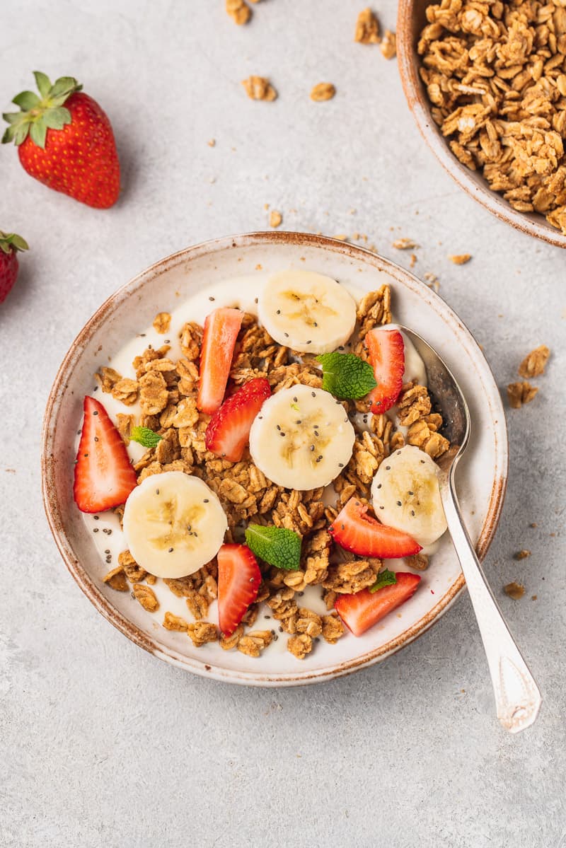 ovehread image of yogurt topped with granola and fruit by sweetsimplevegan