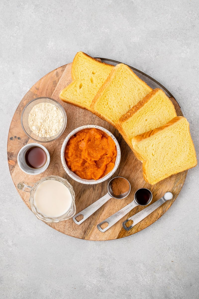 Ingredients for vegan pumpkin french toast on a wooden board