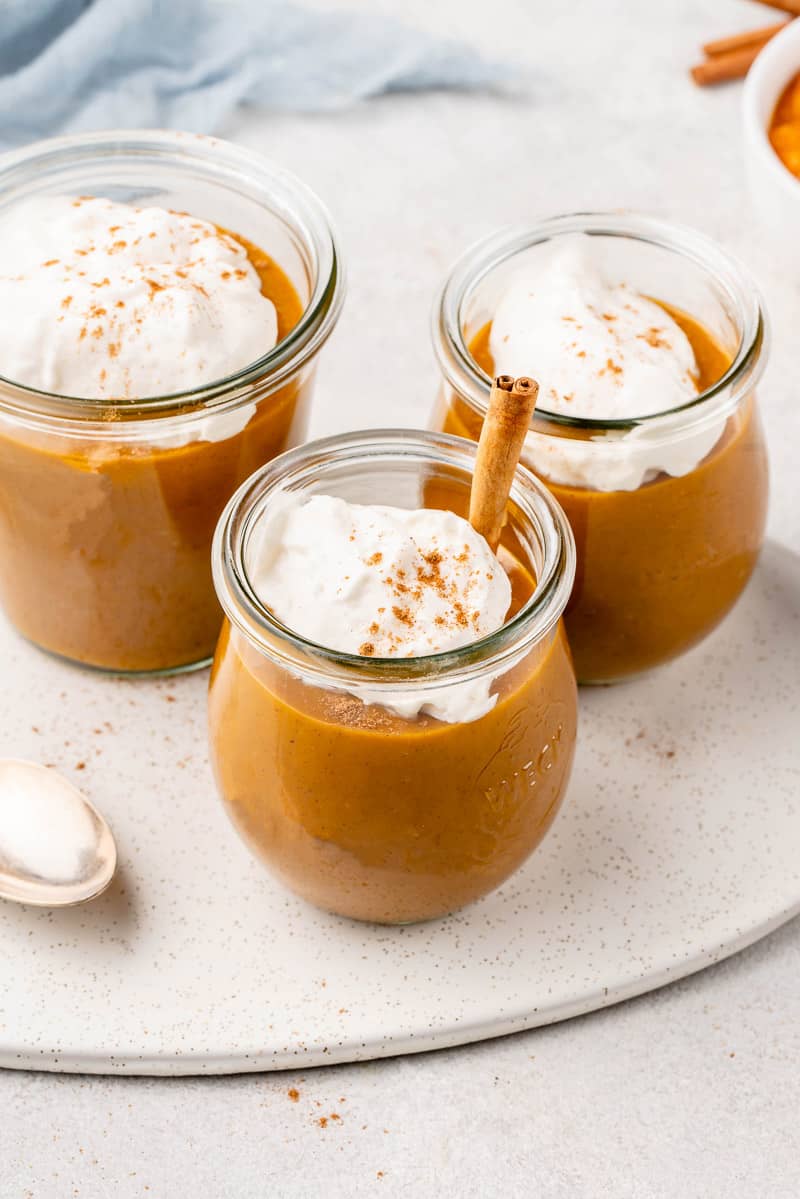jars of pumpkin pie pudding with coconut whipped cream