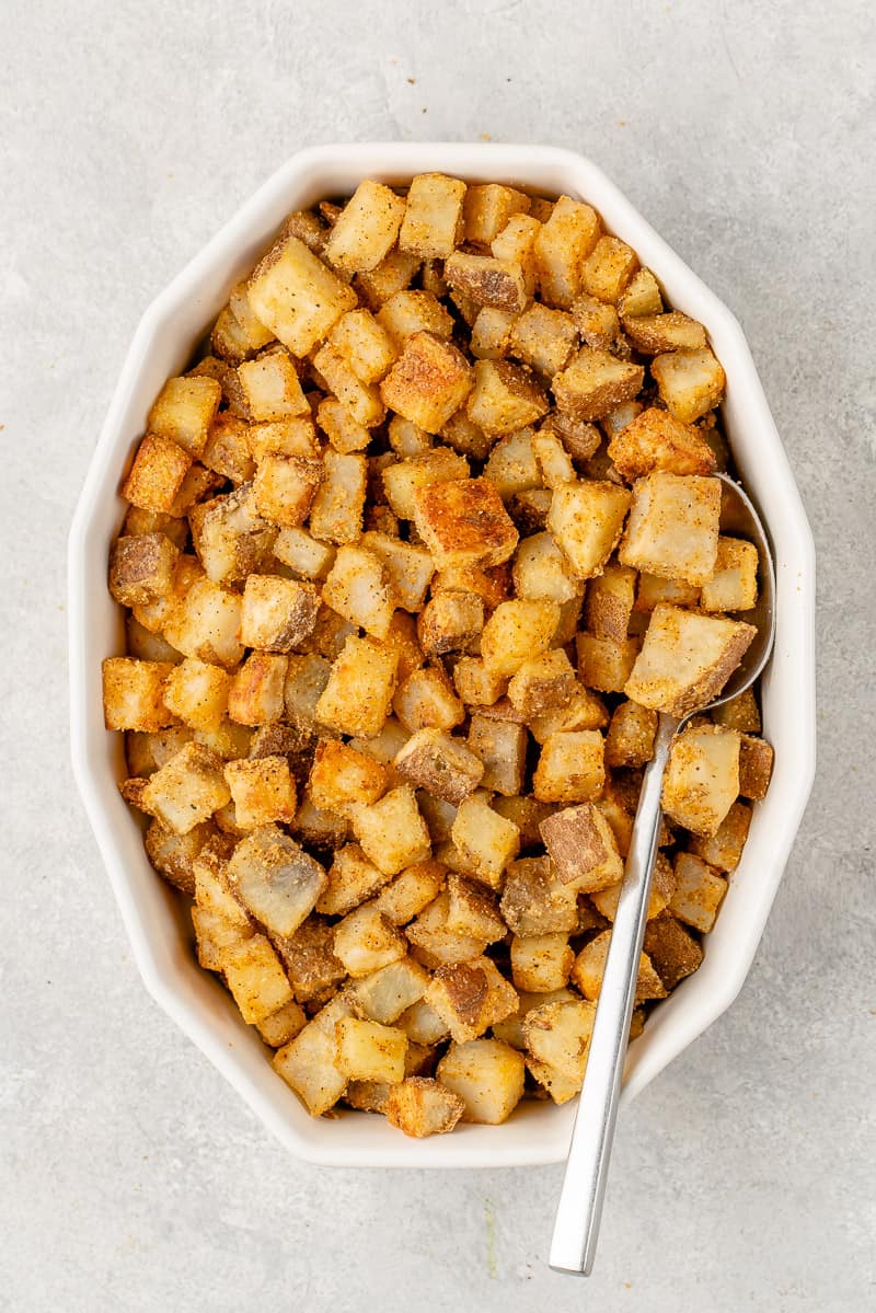 overhead image of crispy fiesta potatoes in baking dish with spoon