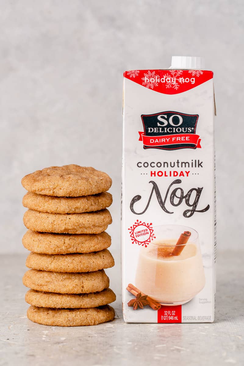 a stack of snickerdoodles next to a carton of vegan eggnog