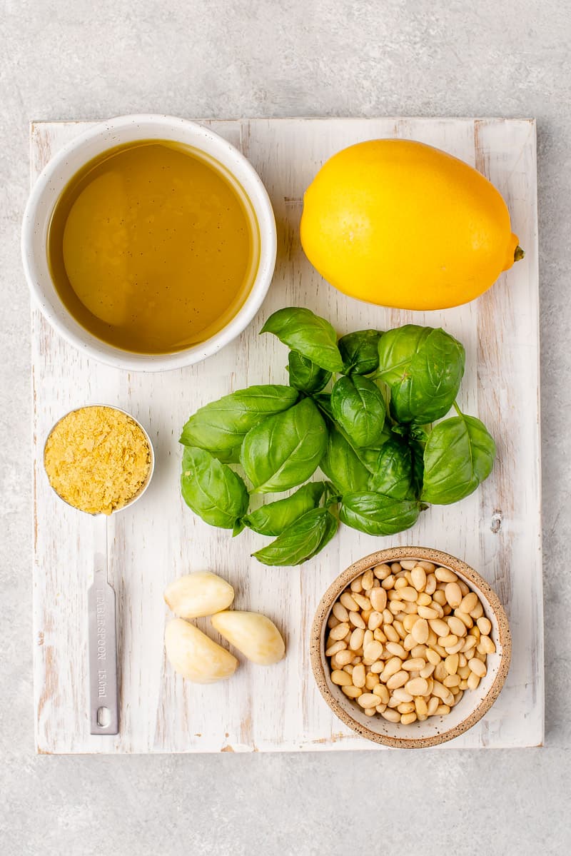 Ingredients to make pesto in a white cutting board