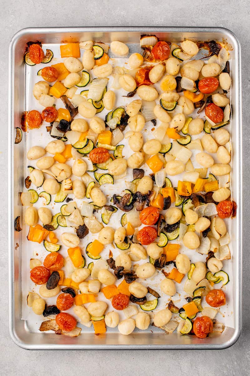 a baking sheet with roasted gnocchi and vegetables