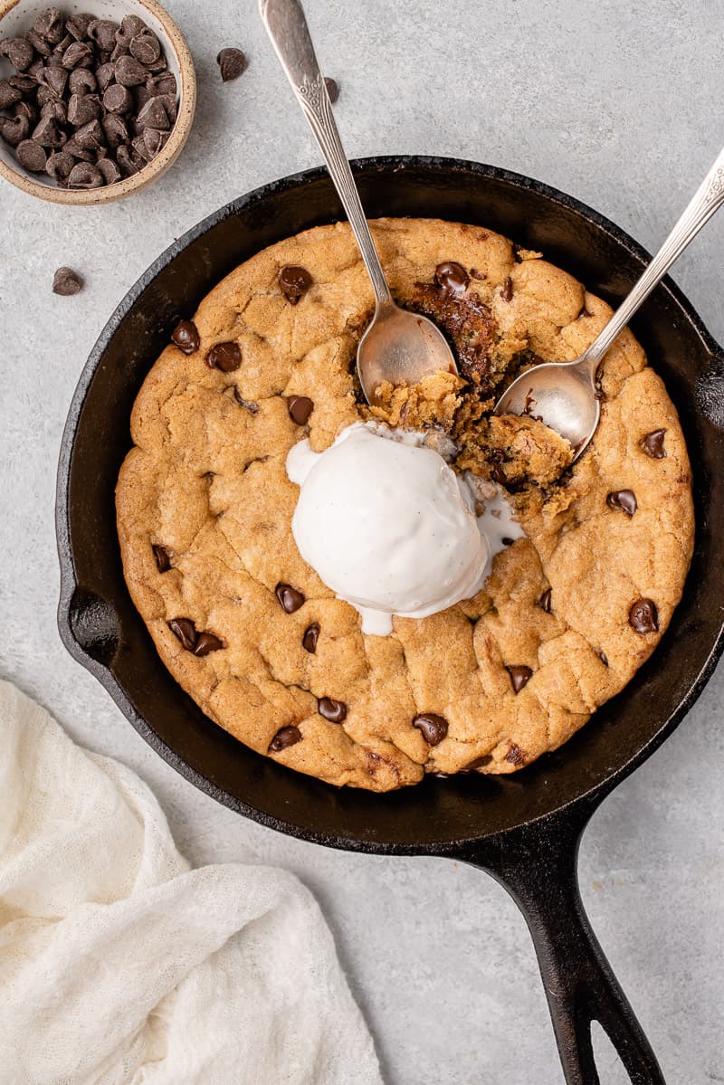 vegan chocolate chip skillet cookie with ice cream being eaten