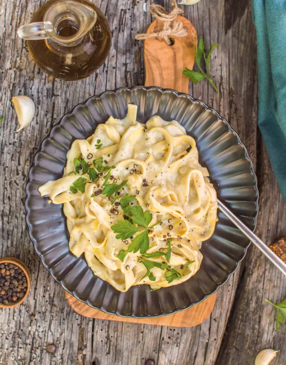 One-pot fettuccine alfredo from an above angle on a black plate with fork. 