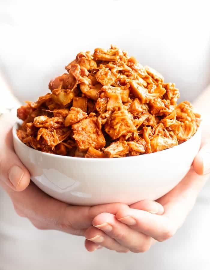 macro image of heaping bowl of BBQ jackfruit being held in hands.