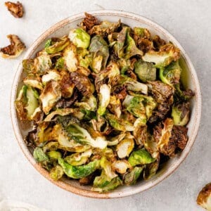overhead image of cooked brussels sprout chips in a bowl