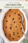 an overhead photo of chocolate chip baked oatmeal with a serving spoon for pinterest