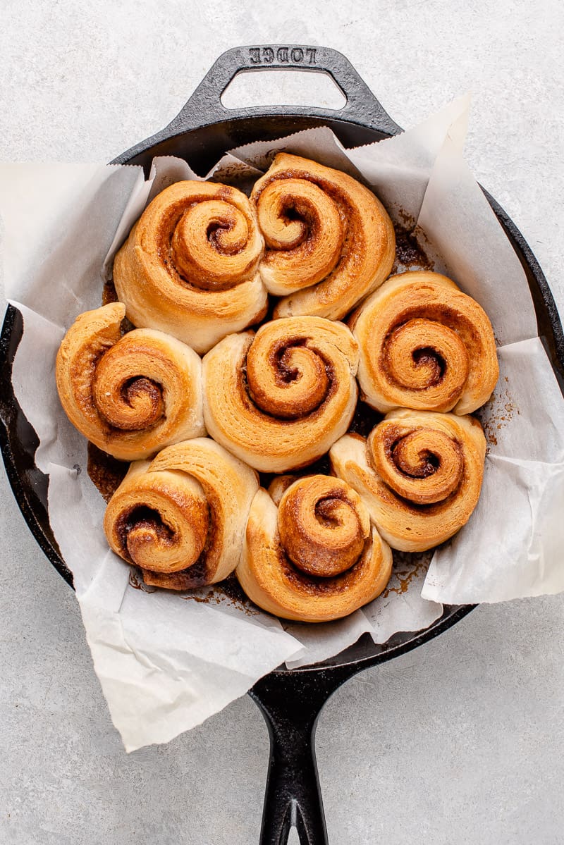 cooked cinnamon rolls in cast iron with parchment paper