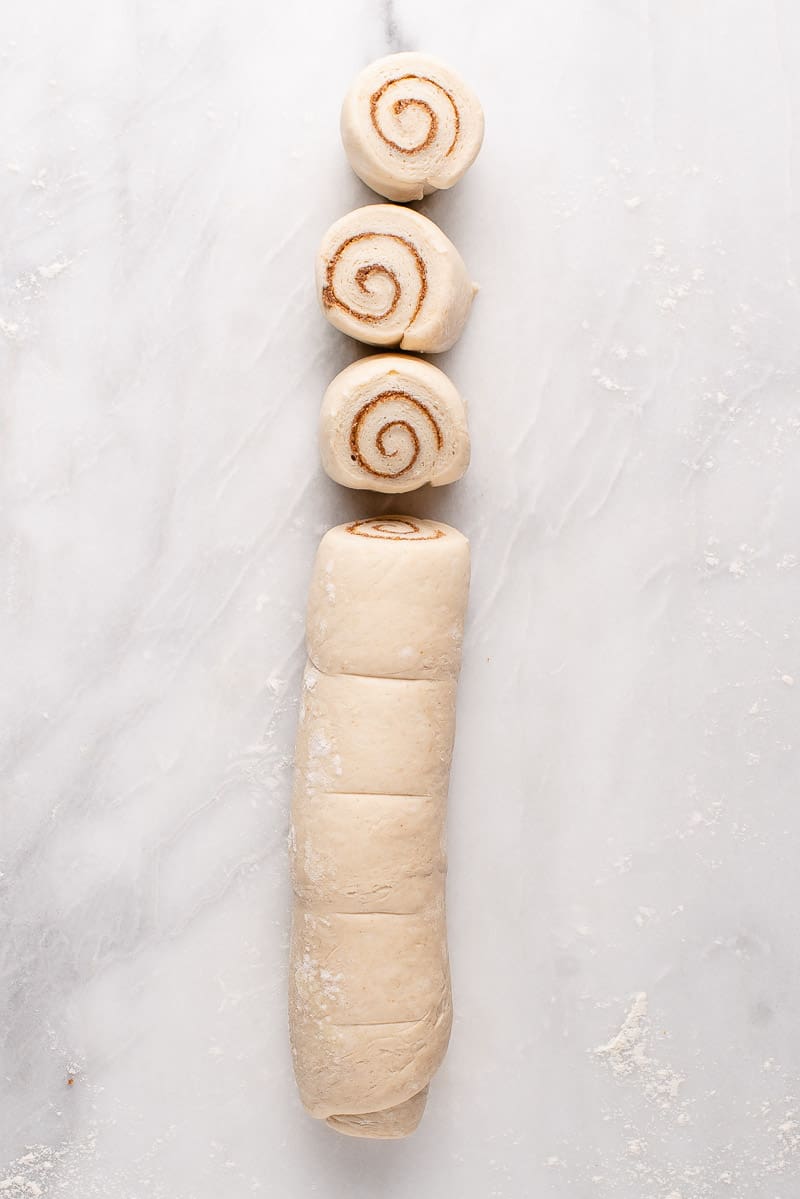 overhead image of uncooked cinnamon rolls half cut in pieces
