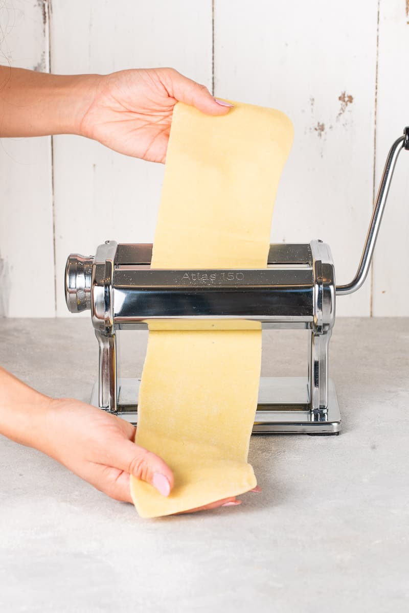pasta being run through a pasta machine
