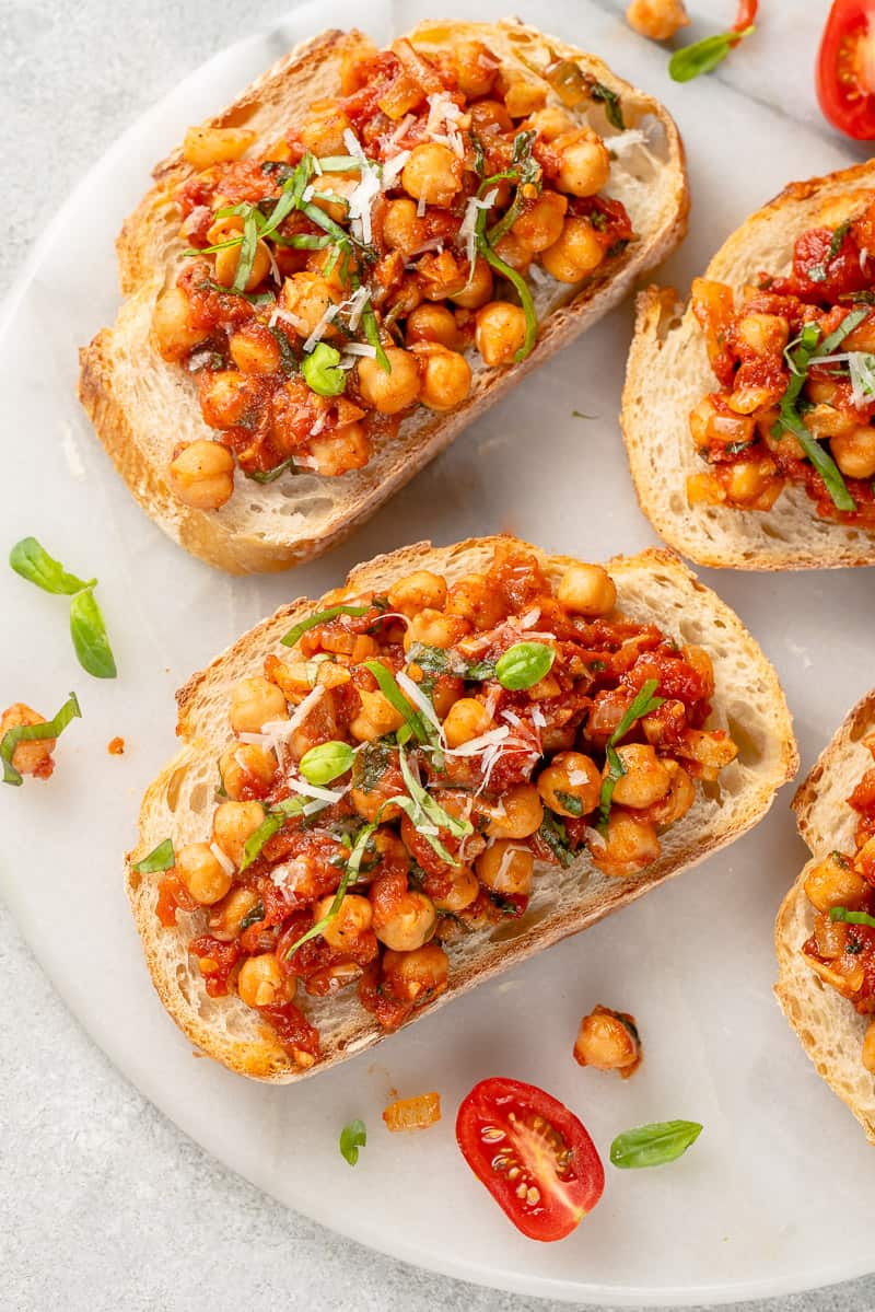 chickpea and tomato toast on white marble board