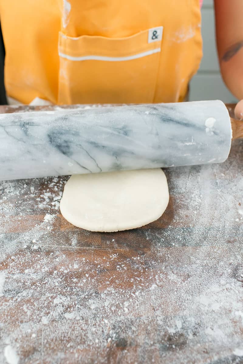 rolling out empanada dough