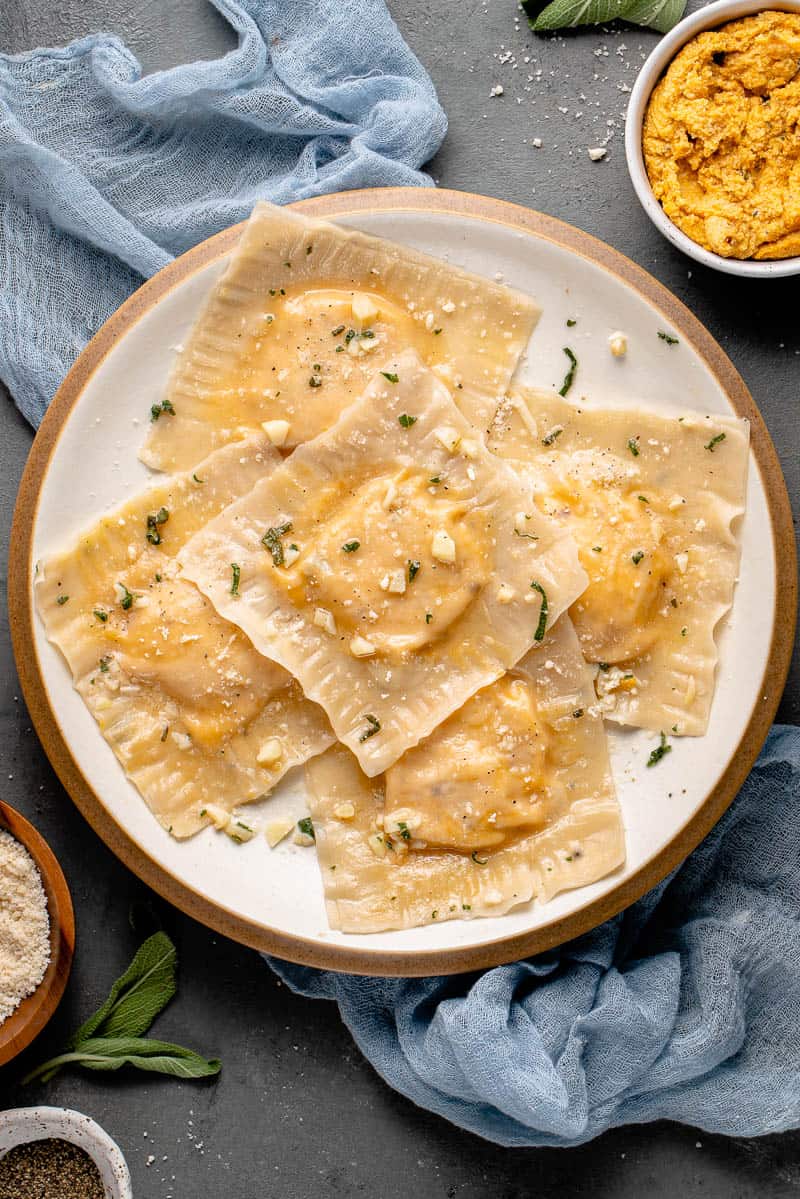 butternut squash ravioli on a white plate with blue towel