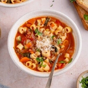 instant pot lentil soup in a white bowl with a spoon and parmesan