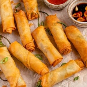 dynamite lumpia on a cutting board with dipping sauces