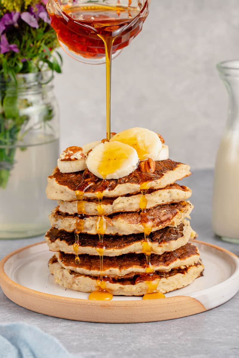 stack of vegan banana pancakes with maple syrup drizzle