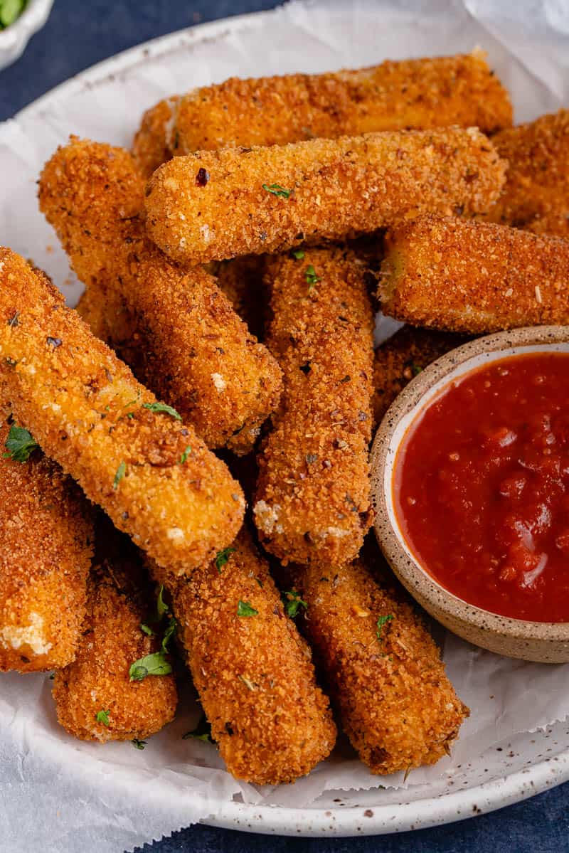 Spicy Dairy-Free Mozzarella Sticks on white plate with marinara