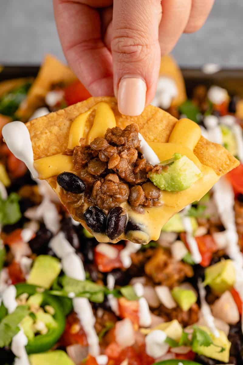 close up of a tortilla chip from loaded vegan nachos