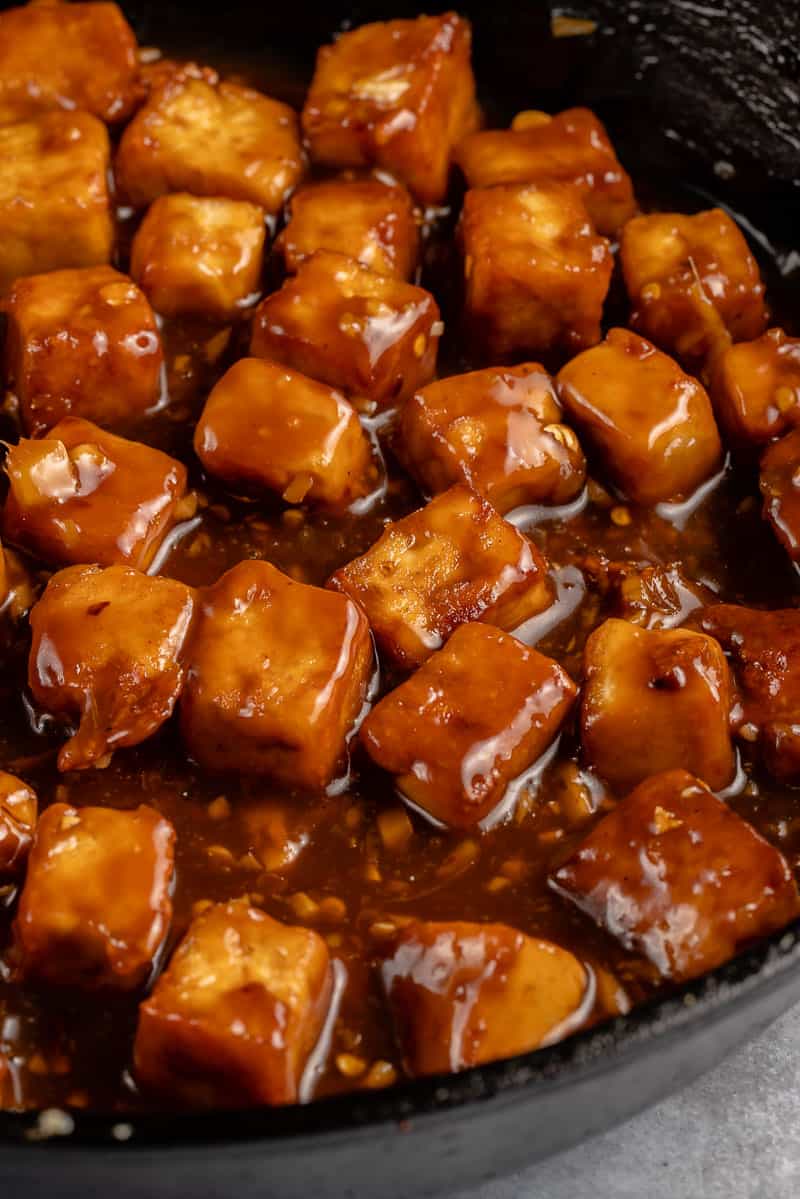 close up of saucy vegan orange tofu in a skillet