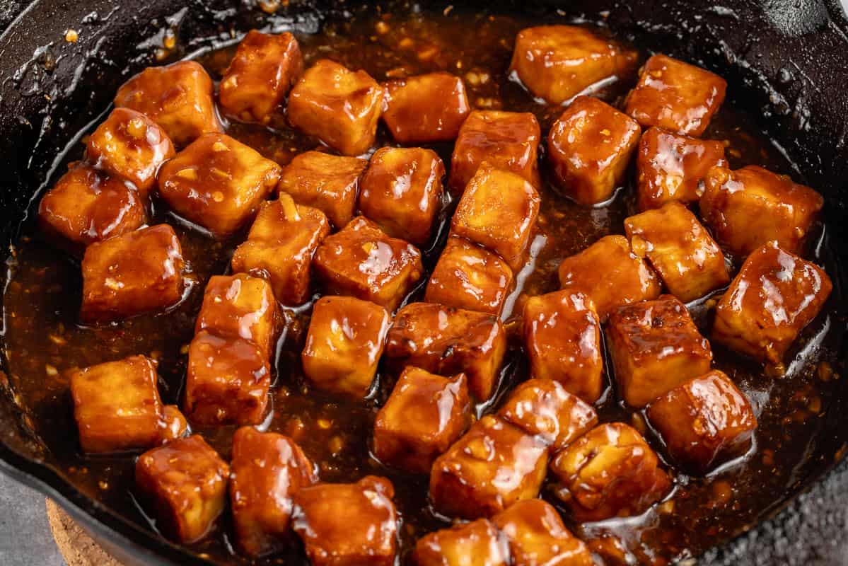 close up of saucy vegan generalo tso's tofu in a skillet