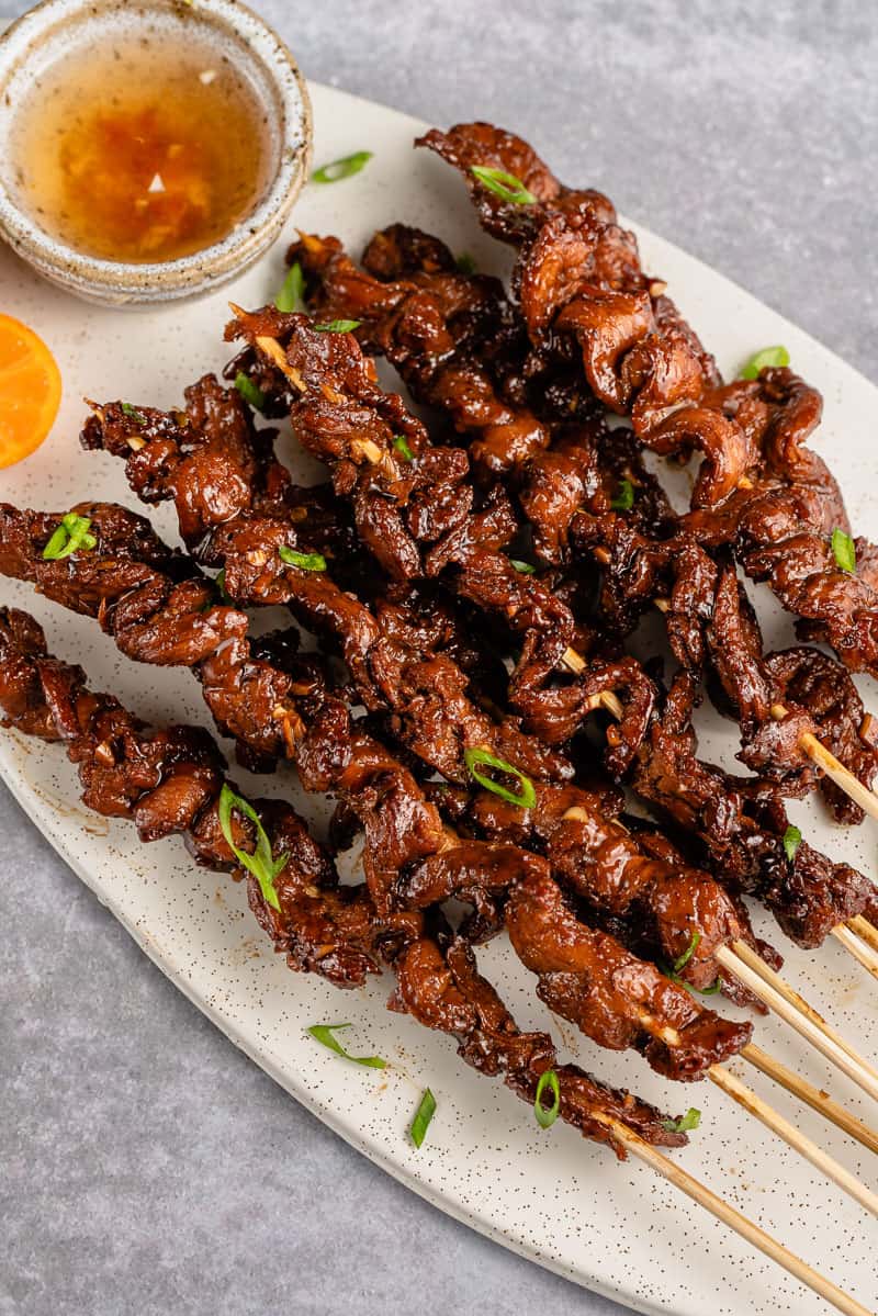 vertical photo of Vegan Filipino Barbecue on skewers with green onions