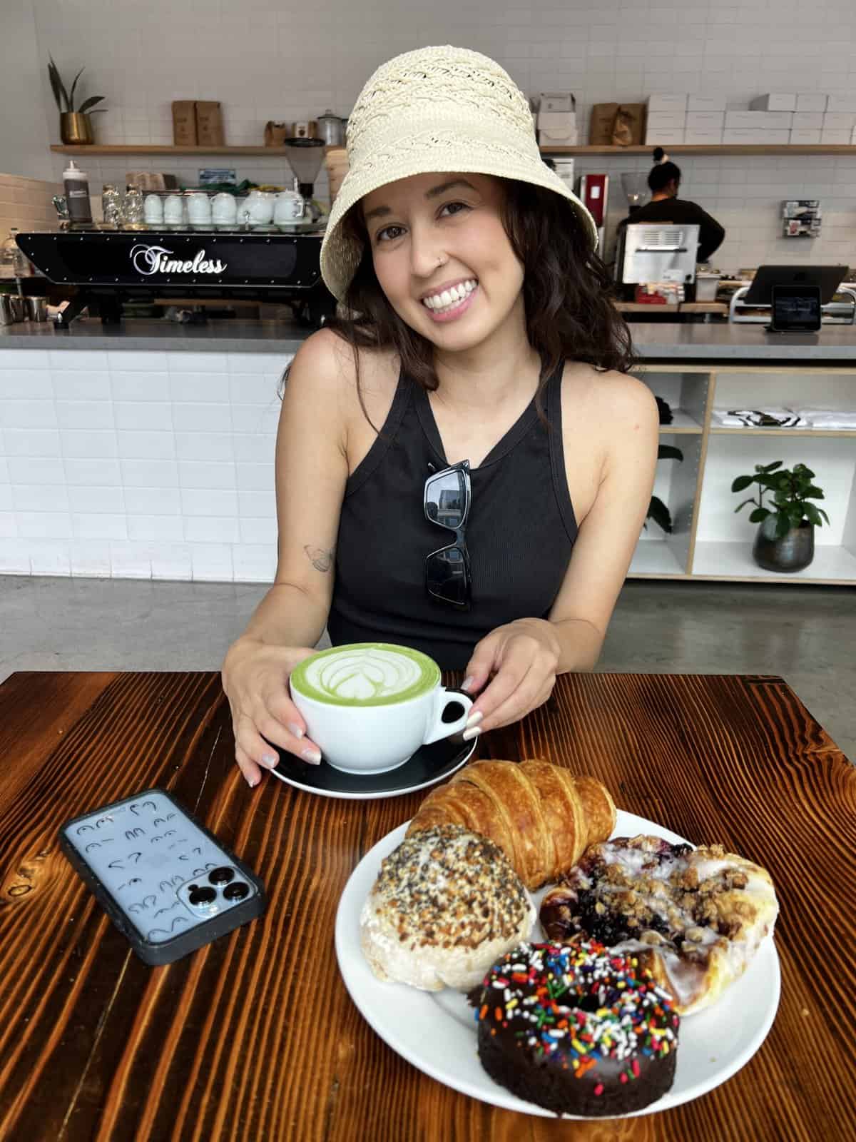 jasmine of sweet simple vegan posing with a matcha latte and pastries
