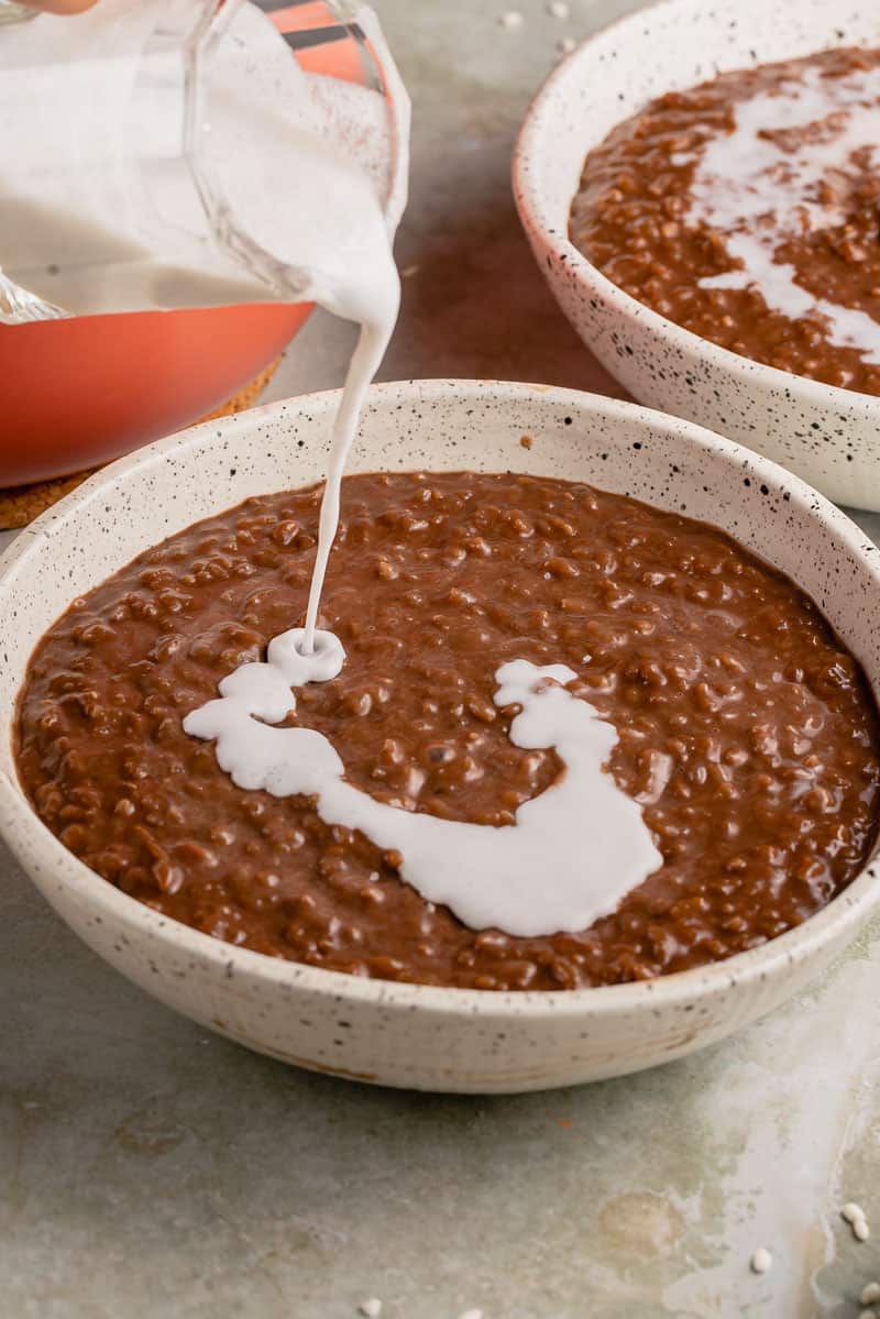image of coconut milk being poured over champorado
