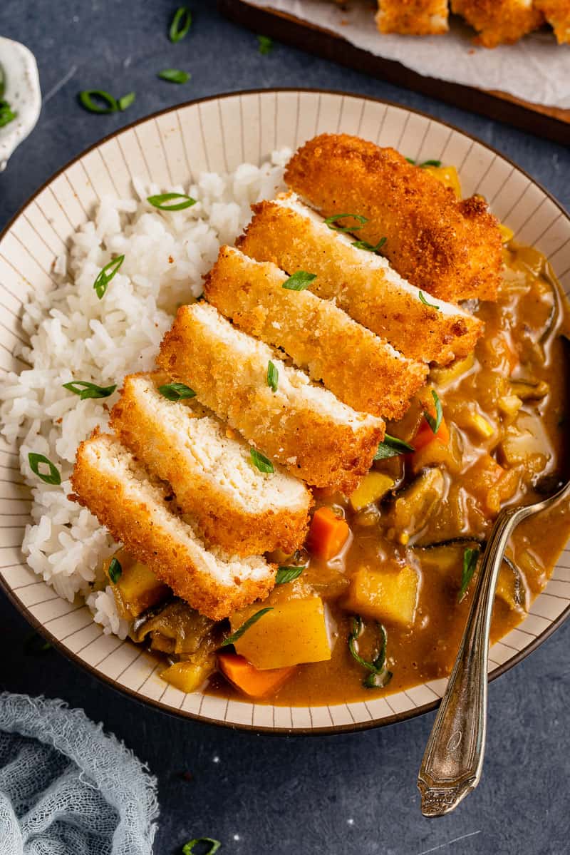 upclose image of katsu and curry in a bowl with spoon