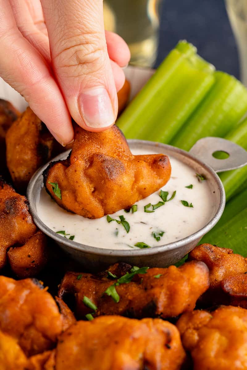 cauliflower wing being dipped into ranch