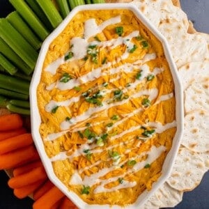 overhead photo of vegan buffalo chicken dip with vegetables and crackers