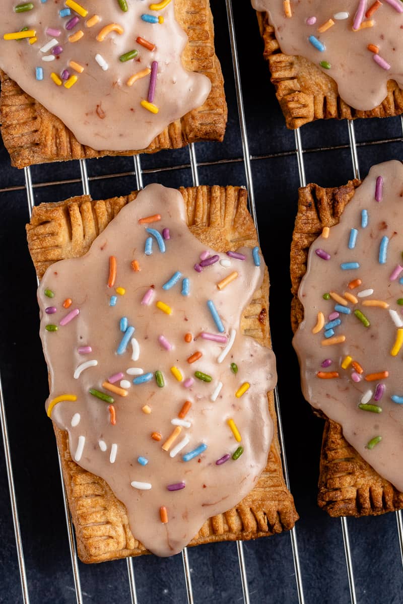 overhead photo of 4 vegan pop tarts with pink icing and sprinkles
